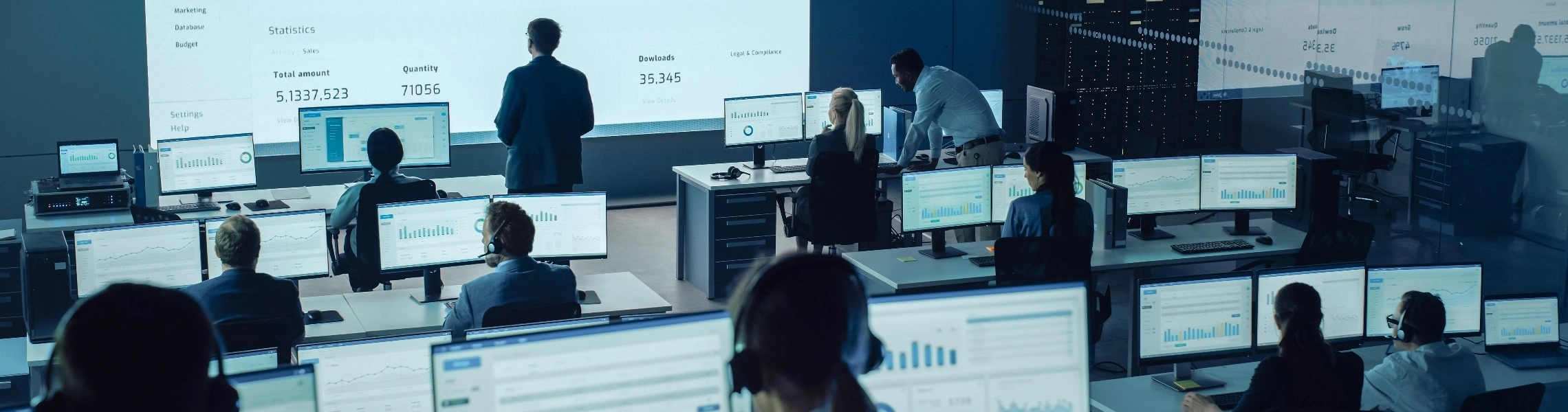 A diverse group of people gathered around a computer screen, engaged in discussion or collaboration