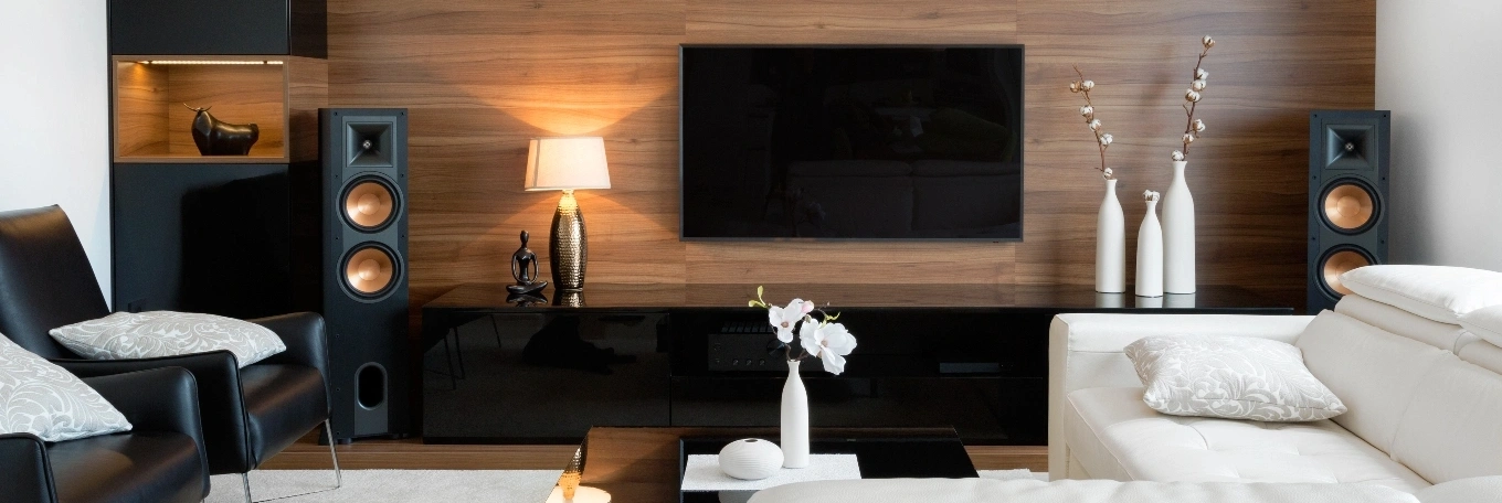 A modern living room showcasing a large television and speakers
