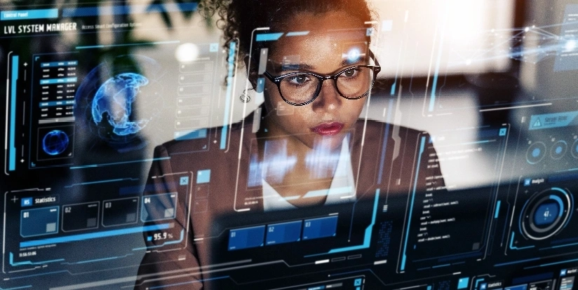 A woman wearing glasses is focused on a computer screen, engaged in her work or research