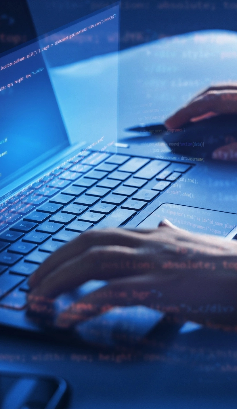 The image depicts a close-up of hands typing on a laptop keyboard