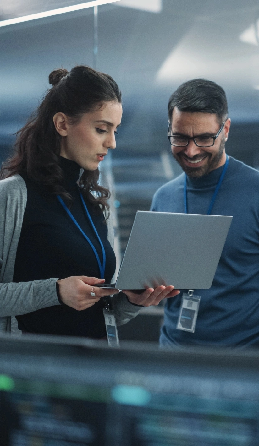 Two people collaborating while looking at a laptop screen together