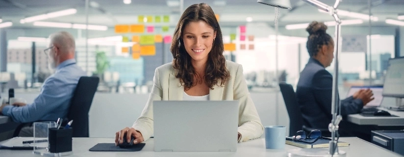 Woman smiling while working on a laptop