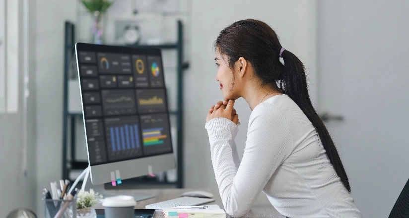 woman sitting at a desk focused on her computer screen